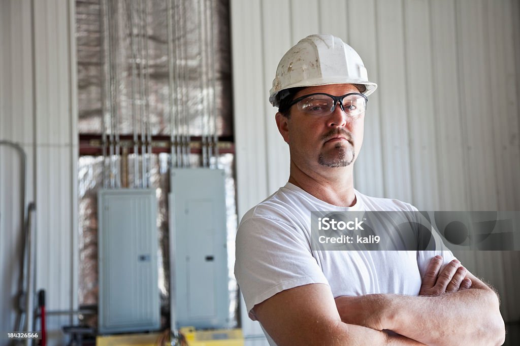 Worker wearing hard hat Portrait of mature man, 40s.  Manual worker in hard hat and protective eyewear. 40-44 Years Stock Photo