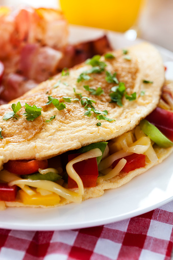 Omlette with vegetables, cheese and bacon, close-up