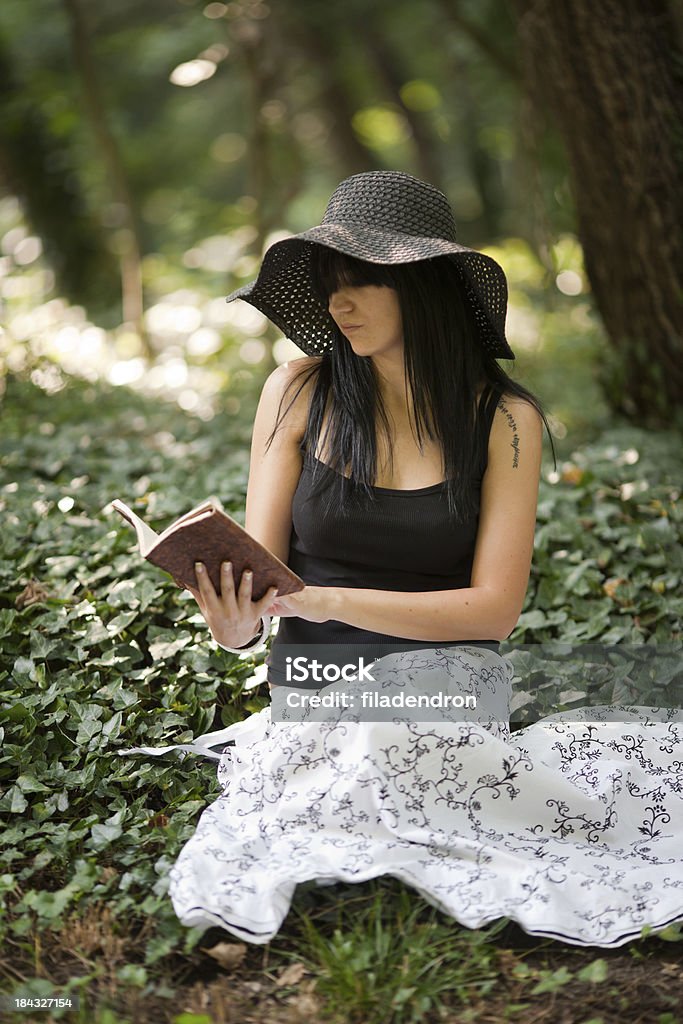 Beautiful girl reading a book outdoor Adult Stock Photo
