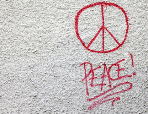A vandal has defaced a surburban house wall by spray painting graffiti with the international peace symbol.