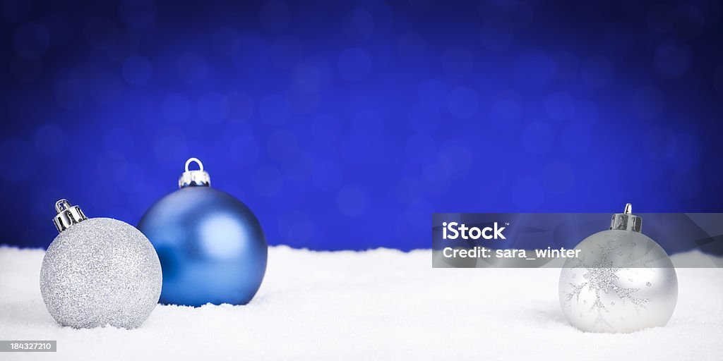 Argent et bleu décorations de Noël sur la neige, fond bleu - Photo de Blanc libre de droits