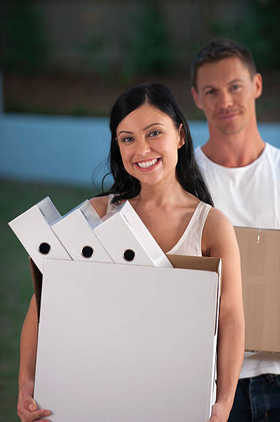 homem e mulher movendo caixas carregando escritório - two people box women 20s - fotografias e filmes do acervo