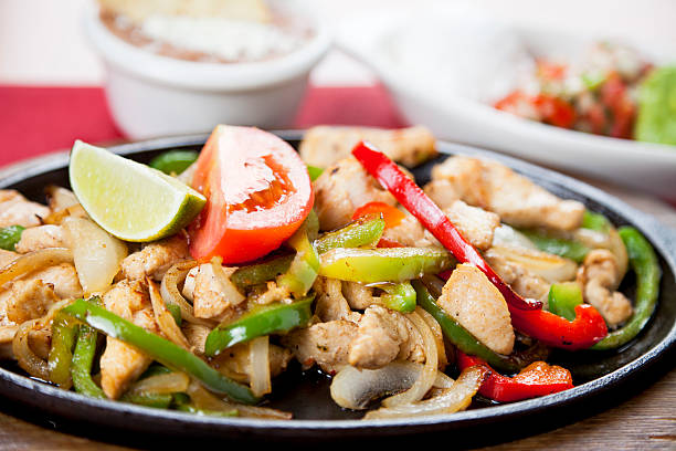 istock Mexican food: chicken fajitas on a hot cast iron skillet 184327728