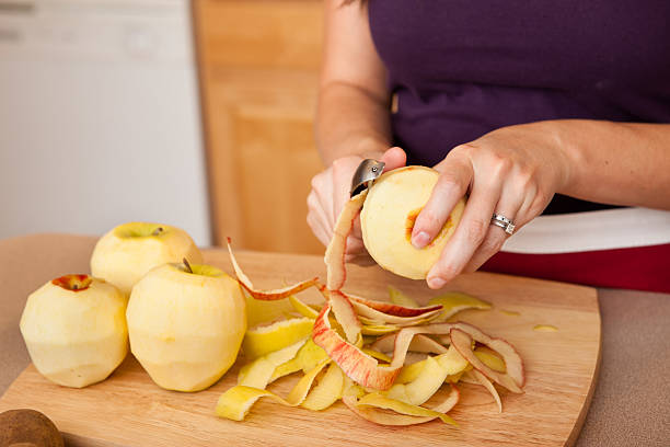 Young Woman Peeling Apples in Kitchen