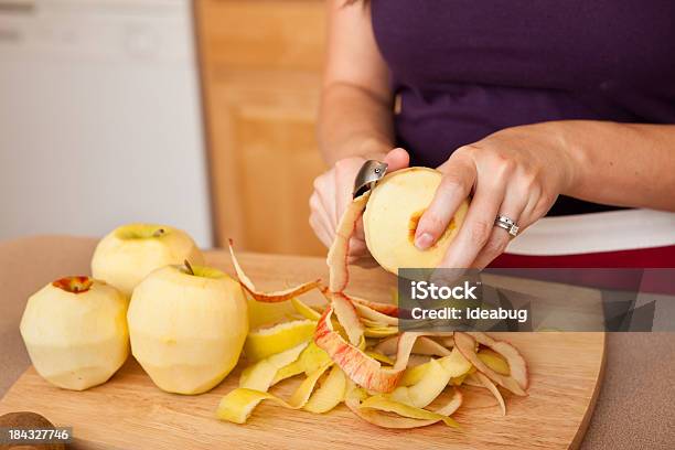 Young Woman Peeling Apples In Kitchen Stock Photo - Download Image Now - Apple - Fruit, Peel - Plant Part, Fruit