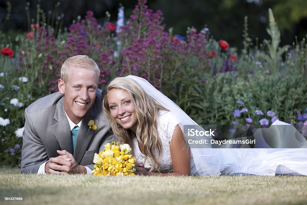 Ritratto di sposi all'aperto con sfondo fiore giardino - Foto stock royalty-free di Abbigliamento formale