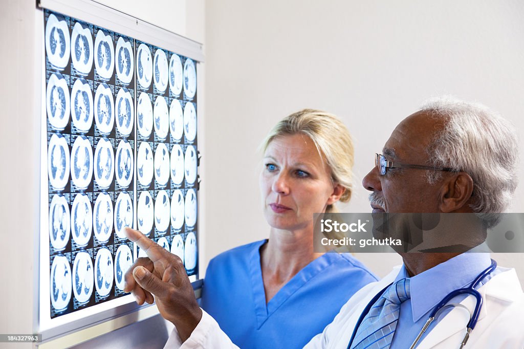 Médico e enfermeira Examing raio-X - Foto de stock de Adulto royalty-free