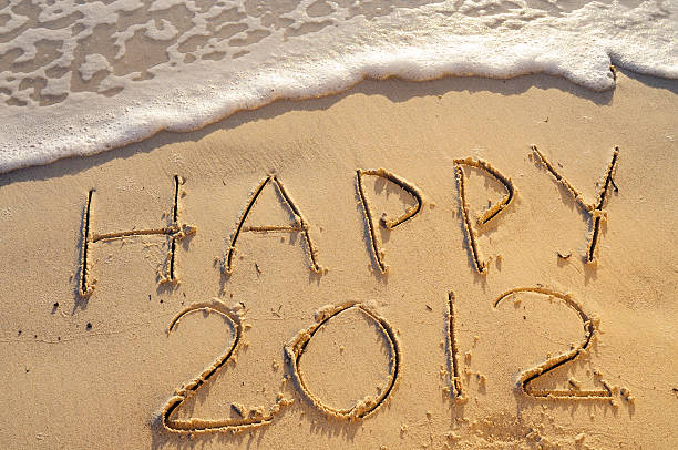 istock Happy New Year Written in the Sand w Wave 184328007