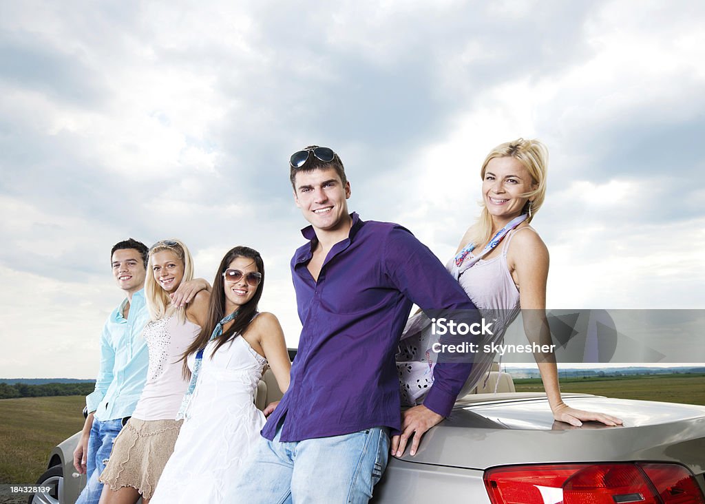 Grupo de jóvenes y un cabriolet automóvil. - Foto de stock de Abrazar libre de derechos