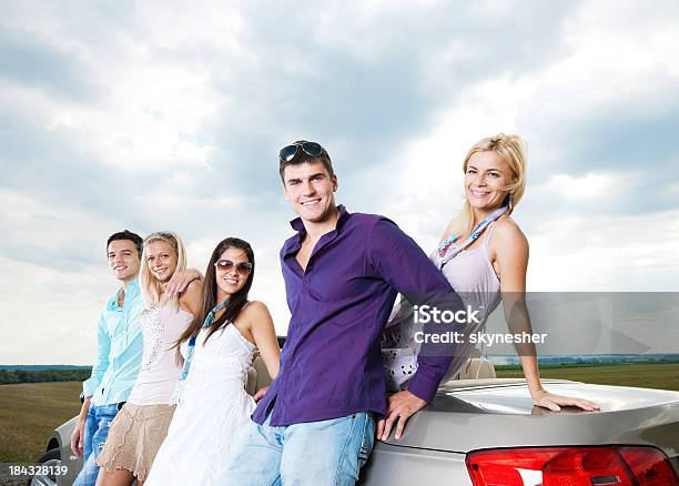 Grupo De Jóvenes Y Un Cabriolet Automóvil Foto de stock y más banco de imágenes de Abrazar - Abrazar, Actividades recreativas, Adulto