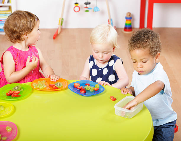 istock Group Of Toddlers Having Healthy Snack In A Nursery Setting 184328266