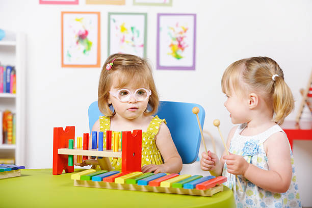 istock Toddler Girls Interacting During Playtime In A Nursery Setting 184328344