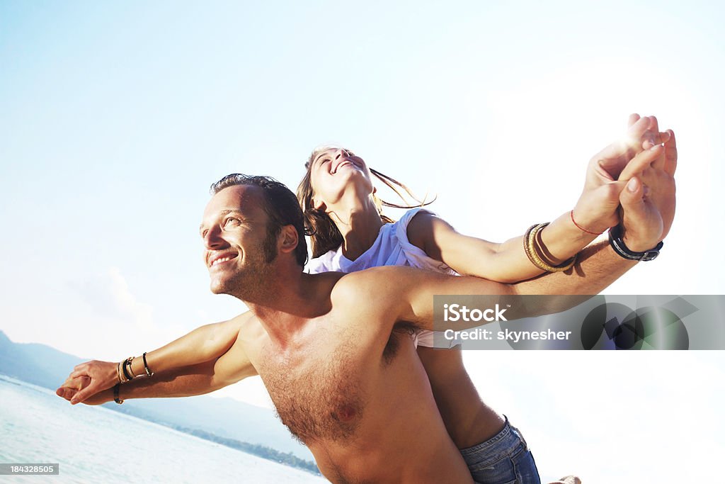 Mann gibt seine Freundin ein Huckepack nehmen Sie am Strand. - Lizenzfrei Aktivitäten und Sport Stock-Foto