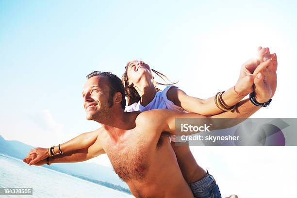 Mann Gibt Seine Freundin Ein Huckepack Nehmen Sie Am Strand Stockfoto und mehr Bilder von Aktivitäten und Sport