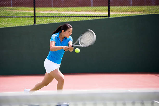 istock Female tennis player hitting a running backhand 184328654