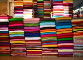Large piles of colorful fabric or textile for sale from market traders feeding the clothing industry manufacturing in Hanoi, Vietnam