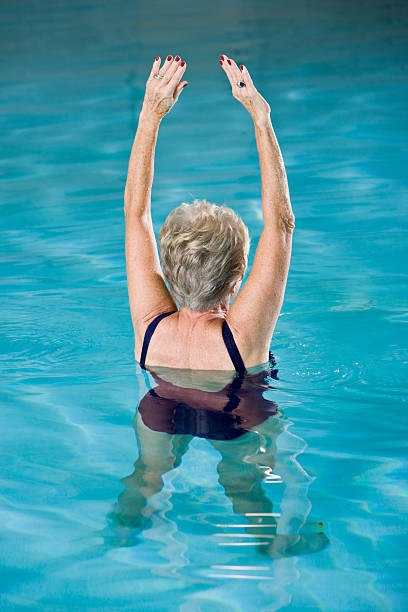 istock Active senior woman exercising in swimming pool 184328730