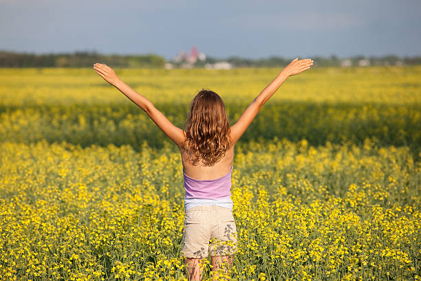 ragazza felice in campo di colza - manitoba canada prairie canola foto e immagini stock