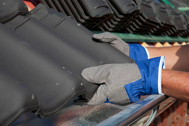 istock Laying tiles on a roof. 184329489