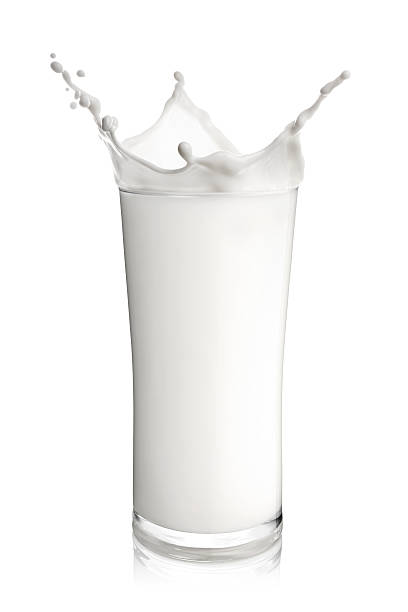Splashing milk Milk glass being filled with a splash. milk stock pictures, royalty-free photos & images