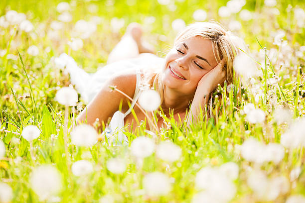 istock Beautiful young woman among dandelions. 184329519