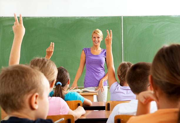 istock Female Teacher Questioning little students 184329542