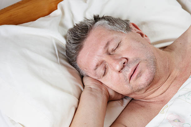 istock Mature man half asleep in bed 184329544