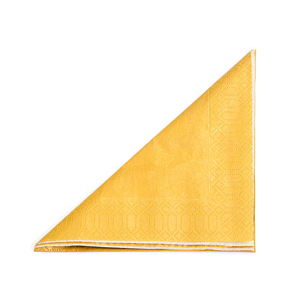 A folded yellow napkin on a white background Golden color napkin on white background napkin photos stock pictures, royalty-free photos & images
