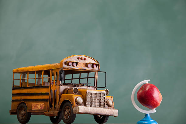 istock School bus and apple as globe on green chalkboard 184329773