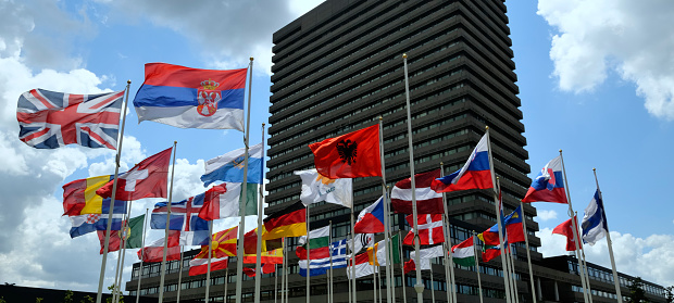 Various European flags in front of an office building.