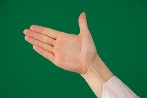 a raised five fingers, hand symbol, viewed from front isolated on green background.