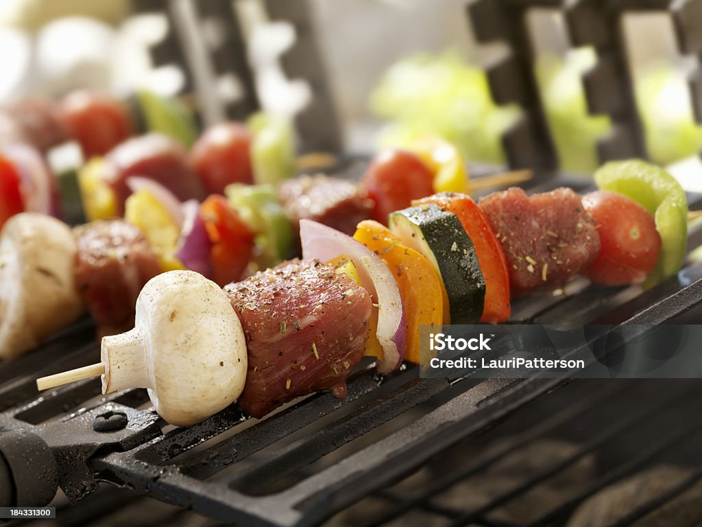 Espetinhos de carne e legumes em um molho de churrasco ao ar livre - Foto de stock de Acampar royalty-free
