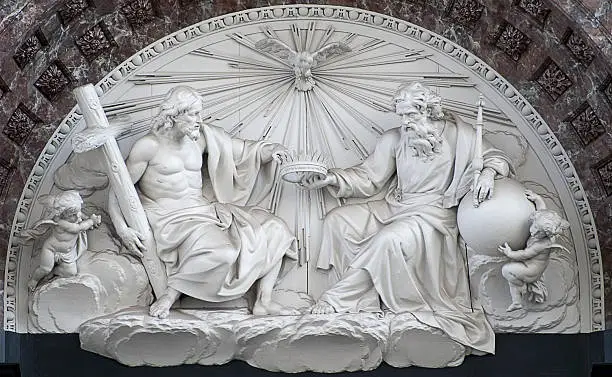 The sculpted pediment (white marble) – representing the Holy Trinity - surmounting the main altar in the Cathedral of Our Lady in Antwerp.  This house of worship is the largest Gothic building in the Netherlands.