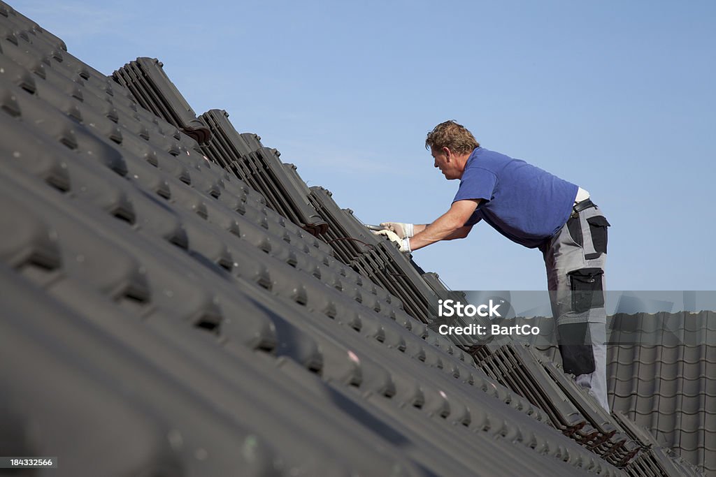 Dekarz pracuje ciężko na dachu. - Zbiór zdjęć royalty-free (Dekarz)