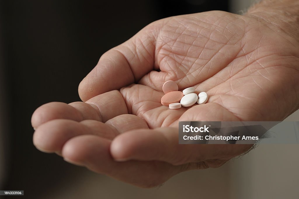 Uomo anziano tenendo la mano di farmaco - Foto stock royalty-free di 80-89 anni