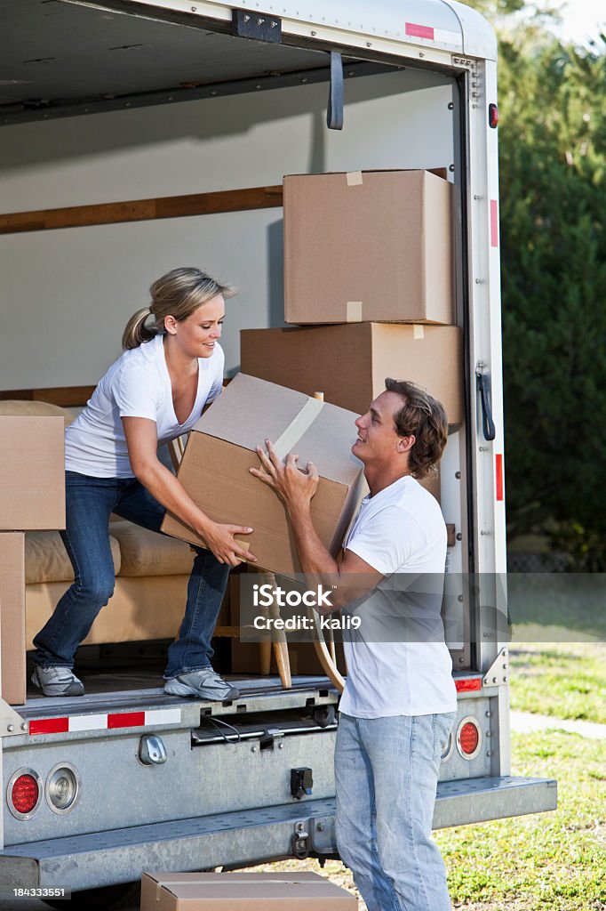 Молодая пара с Машина для перевозки мебели в Подъезд поднимая коробки - Стоковые фото Движение роялти-фри
