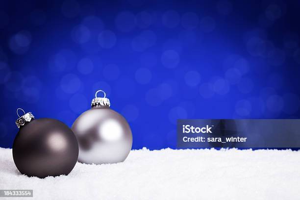 Plata Y Negro Adornos Navideños En La Nieve Fondo Azul Foto de stock y más banco de imágenes de Adorno de navidad