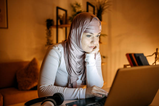 istock Young woman working late night at home using laptop 1843338060