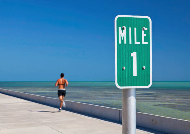 Running Mile One sign and a man running in Key West RUNNING A MILE stock pictures, royalty-free photos & images