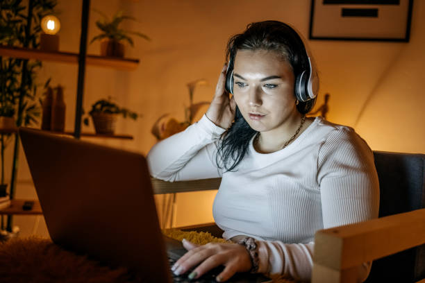 istock Young woman working late night at home using laptop 1843340042
