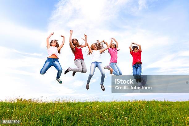 Group Of Happy Chilldren Jumping Outdoors Stock Photo - Download Image Now - Activity, Adolescence, Blue