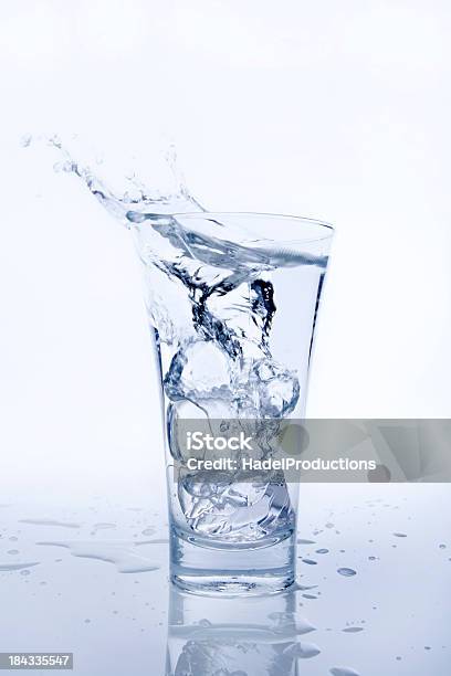 Agua En El Vaso Con Hielo Cube Falling Foto de stock y más banco de imágenes de Actividad - Actividad, Agua, Agua carbonatada