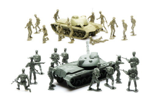 Plastic toy army men standoff with tanks isolated on a white background. More army men and tanks in my lightbox below...