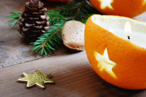 traditional chrismas decoration such as orange halves with star shped holes, golden star,fir branch and pine cone on wooden background