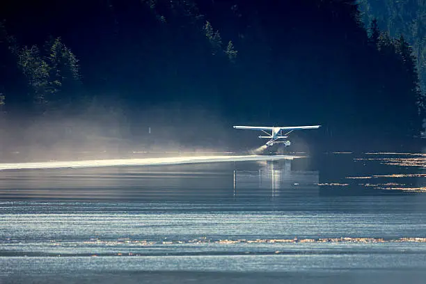 A seaplane taking off from a remote inlet on the Alaskan Coast.
