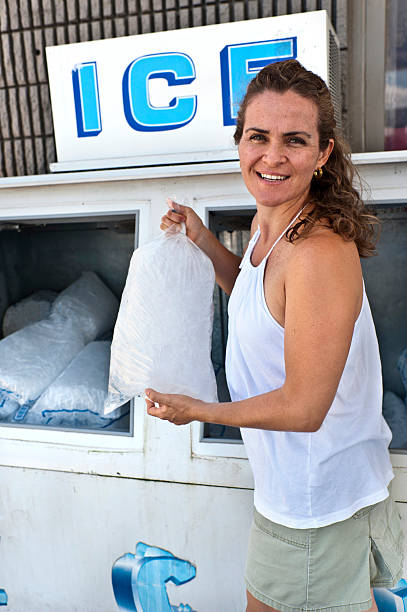 Woman Buying Ice Caucasian Woman buying a bag of ice ice machines stock pictures, royalty-free photos & images