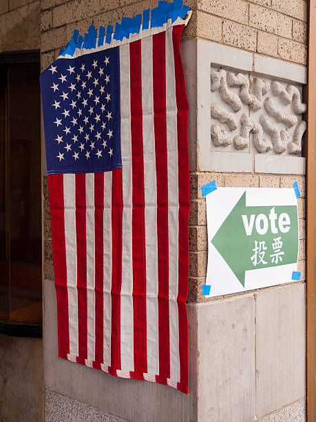 US flag and a sign pointing to polling booth