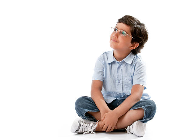 Little boy sitting on white "Little boy sitting on white background looking up, with copy space to viewpoint" one little boy stock pictures, royalty-free photos & images