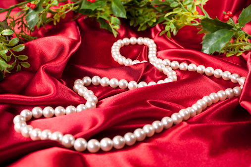 Garland with string of pearls on red satin