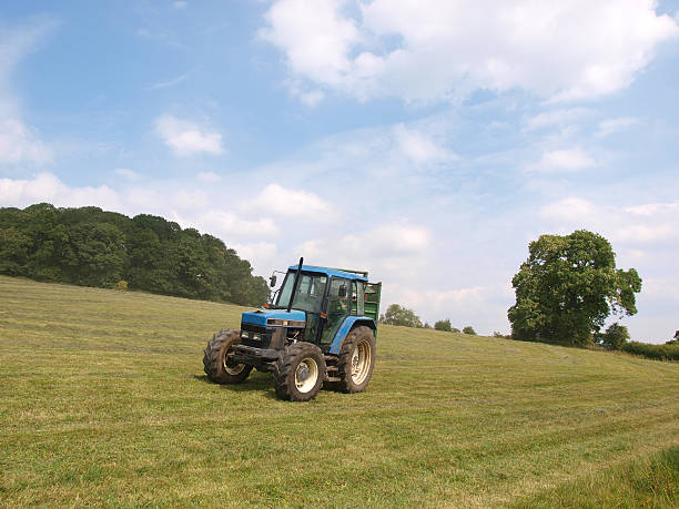 istock tractor on a mown field 184339586